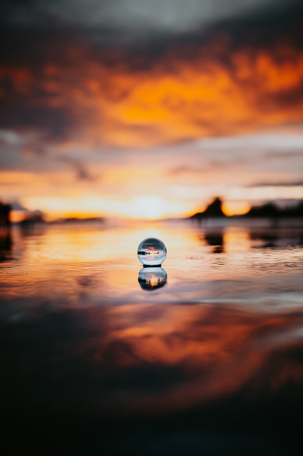 a blurry photo of the ocean with a sunset in the background