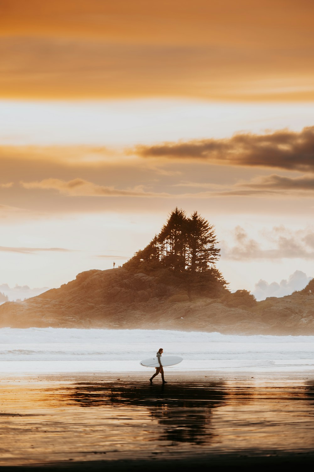 a person walking on the beach with a surfboard