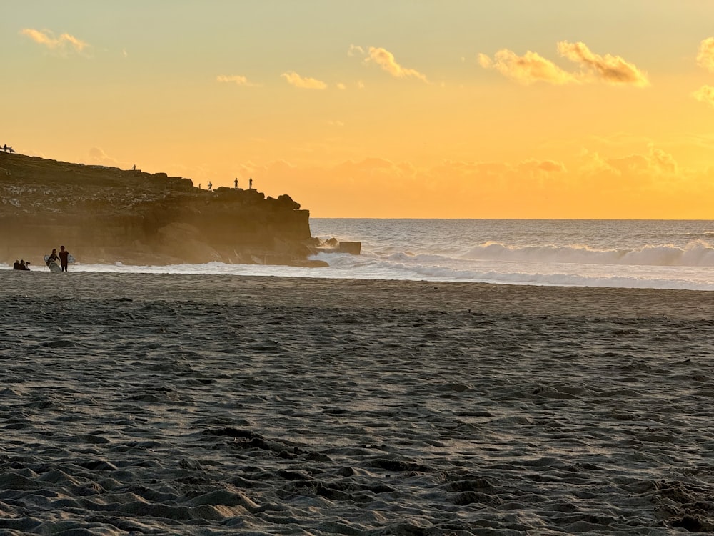 a group of people standing on top of a sandy beach