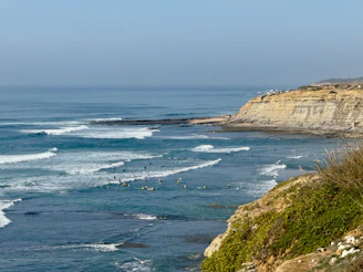 A panoramic shot of the coastline near Lima with surfers catching waves.