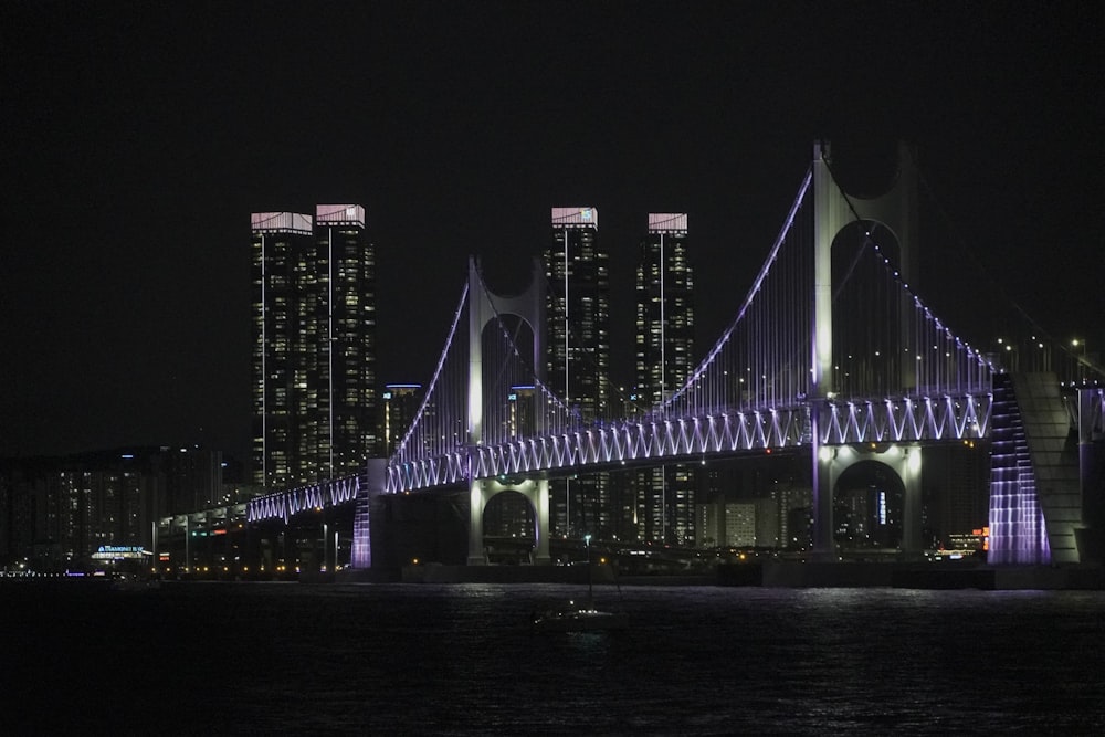 a bridge lit up at night over a body of water