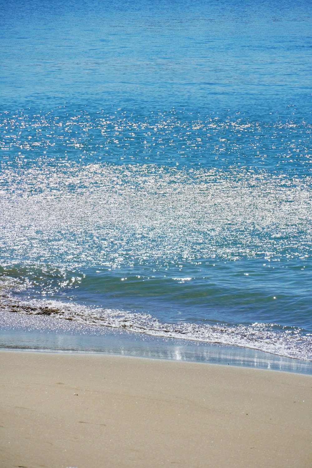 a person walking on the beach with a surfboard