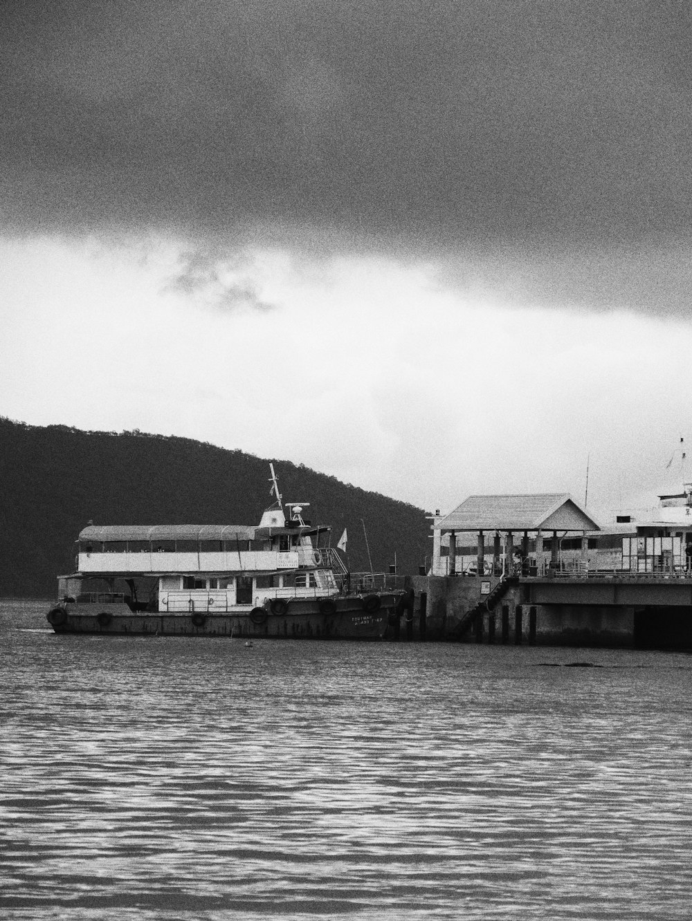 a boat is docked at a pier on a cloudy day