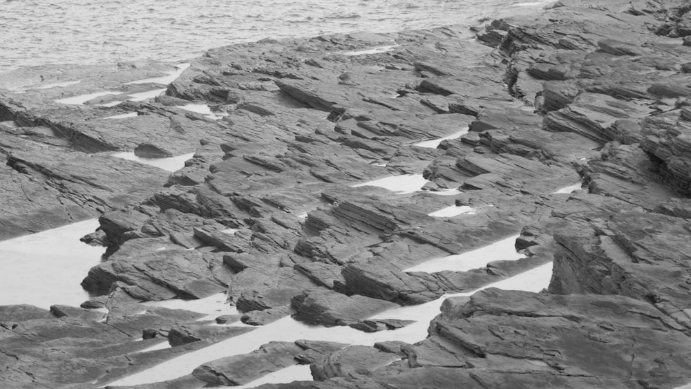 a black and white photo of rocks and water