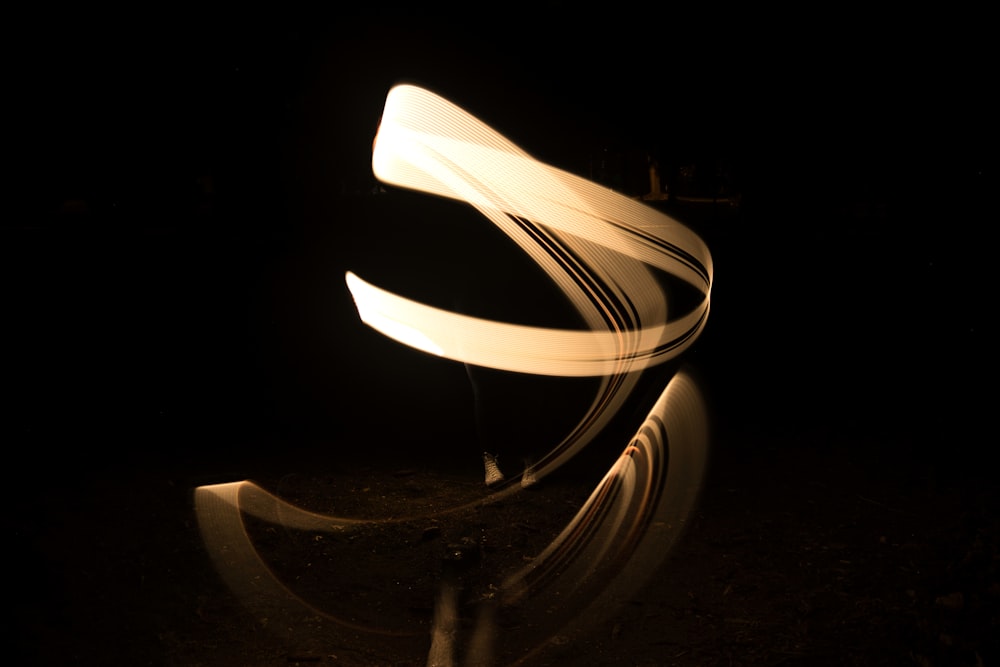 a long exposure photo of a curved object in the dark