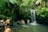 A group of travelers exploring a lush tropical forest with a waterfall in the background.