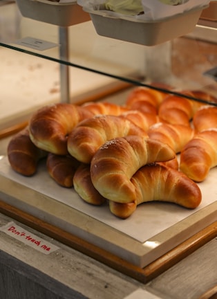 Golden croissants and pastries arranged on a bakery display.