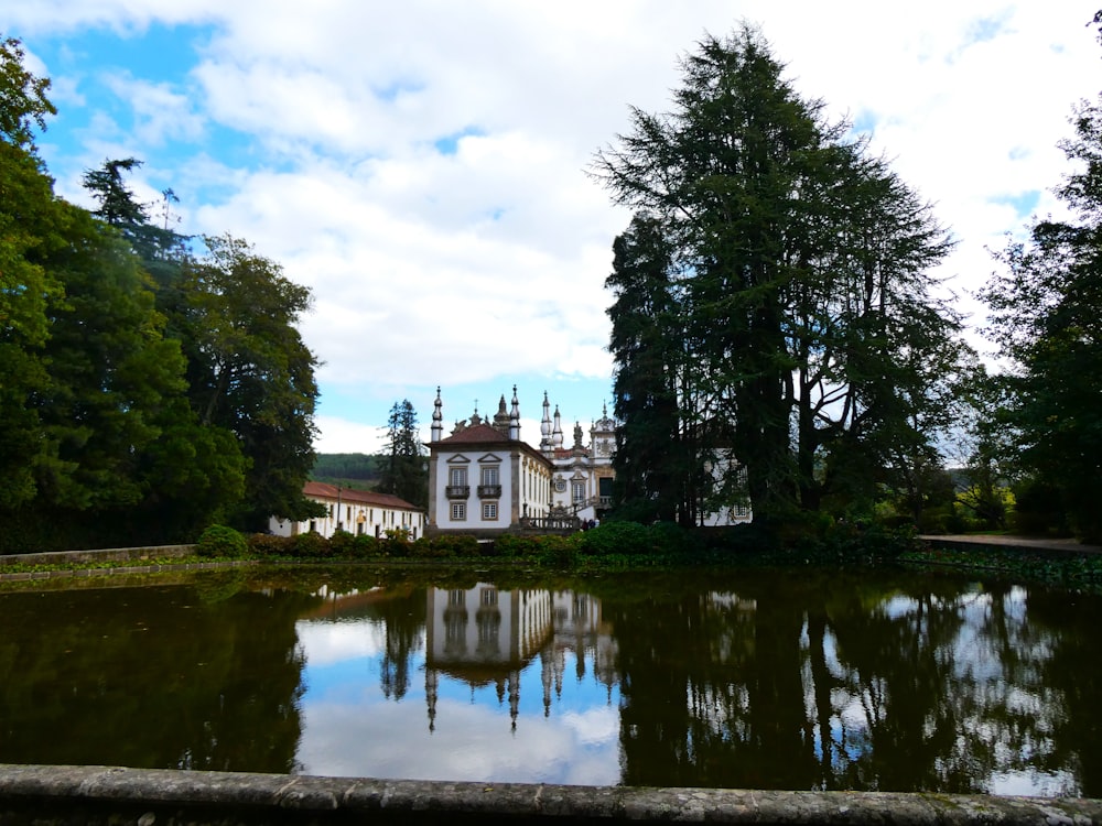 un grande edificio bianco seduto vicino a un lago