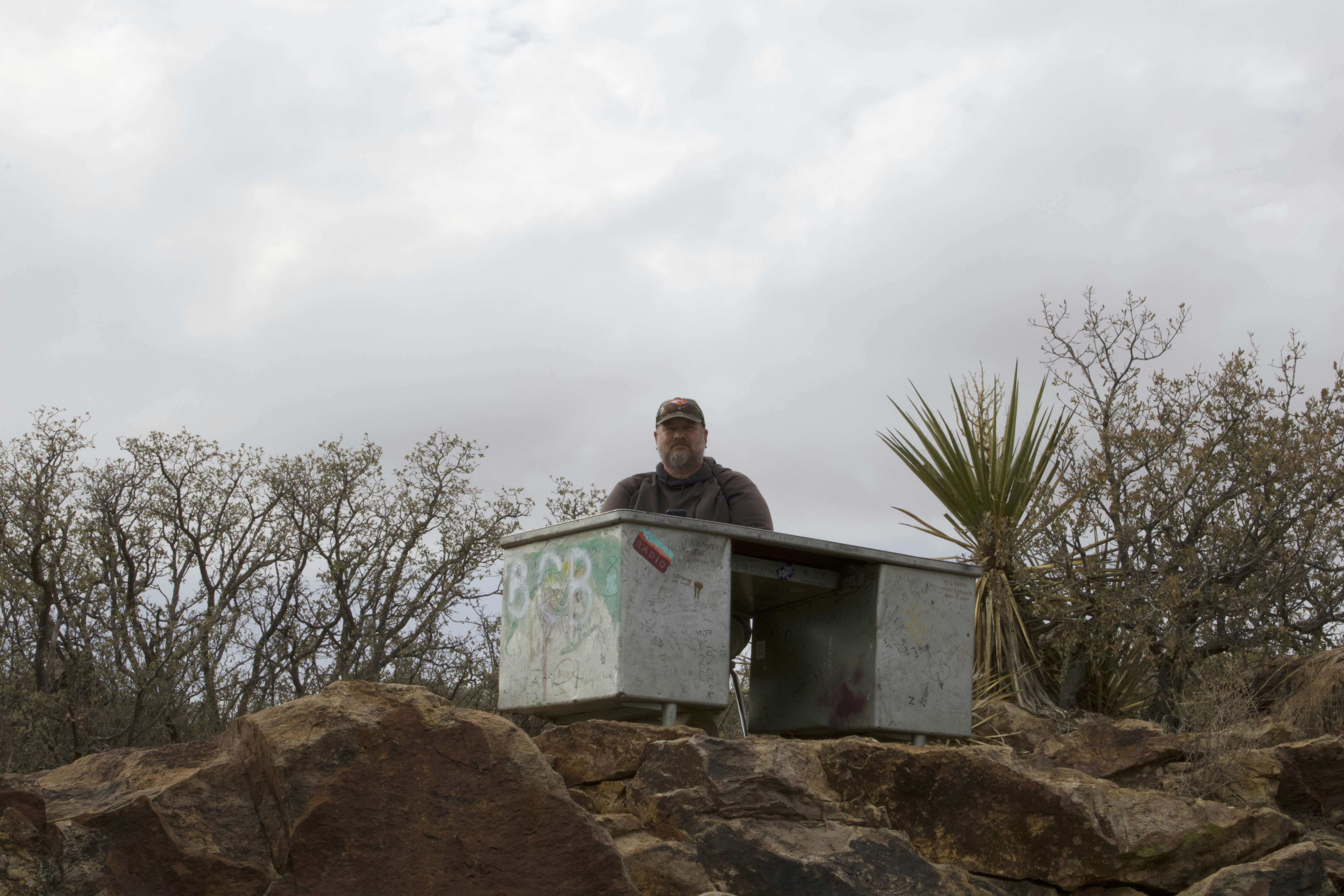 a man sitting at a table on top of a pile of rocks