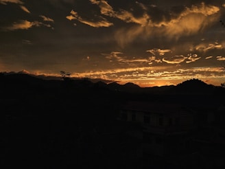 A panoramic sunset casting golden hues over the dramatic Scottish Highlands landscape.