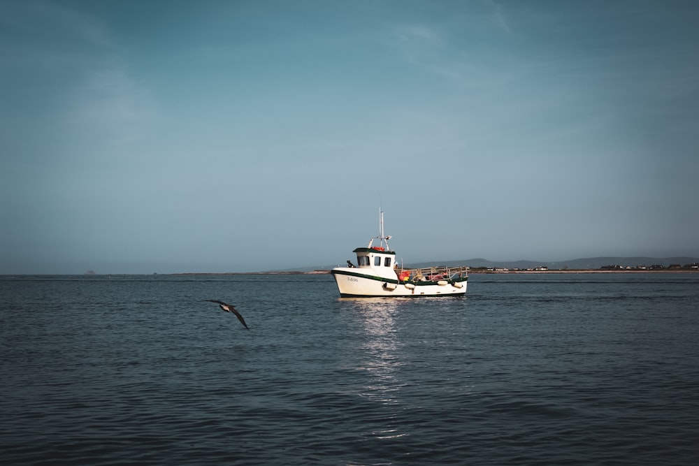 a white boat floating on top of a large body of water