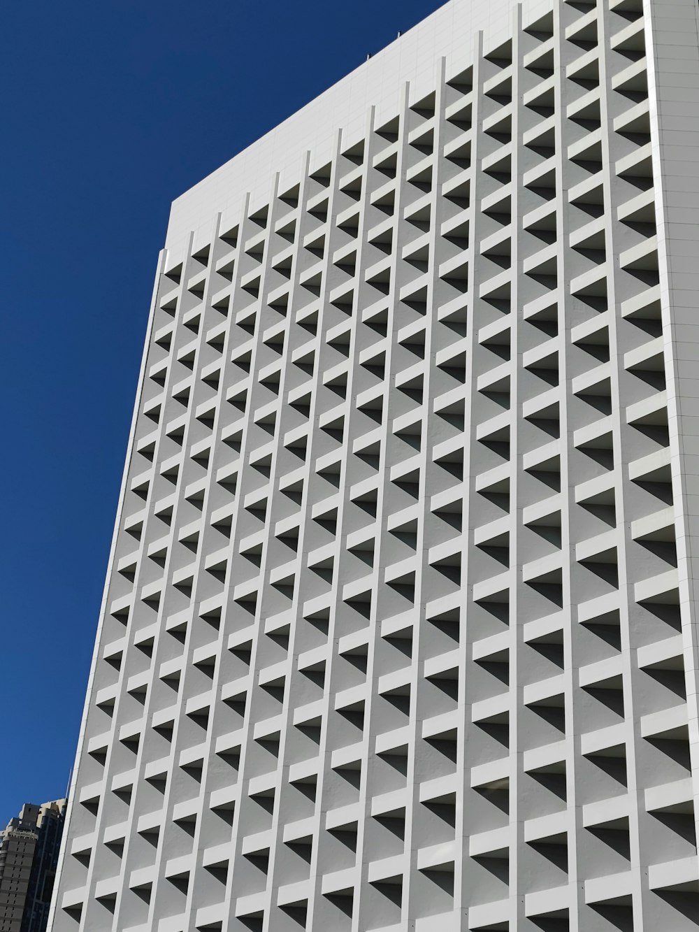 a tall white building with a sky in the background