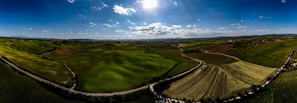 A panoramic view of rolling hills seen from a mountain bike path during a bright sunny day.