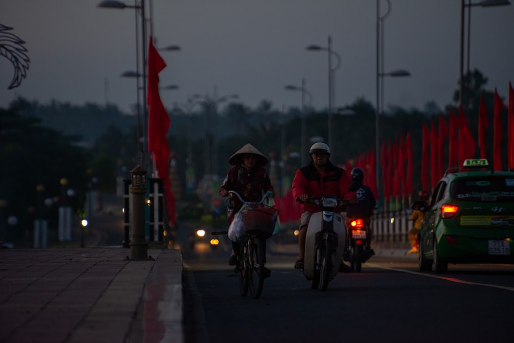 a couple of people riding bikes down a street