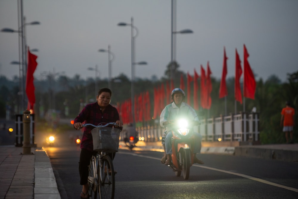 a couple of people riding bikes down a street