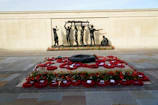 A solemn moment at Gallipoli, Scouts gathered around a memorial with poppies scattered on the ground.