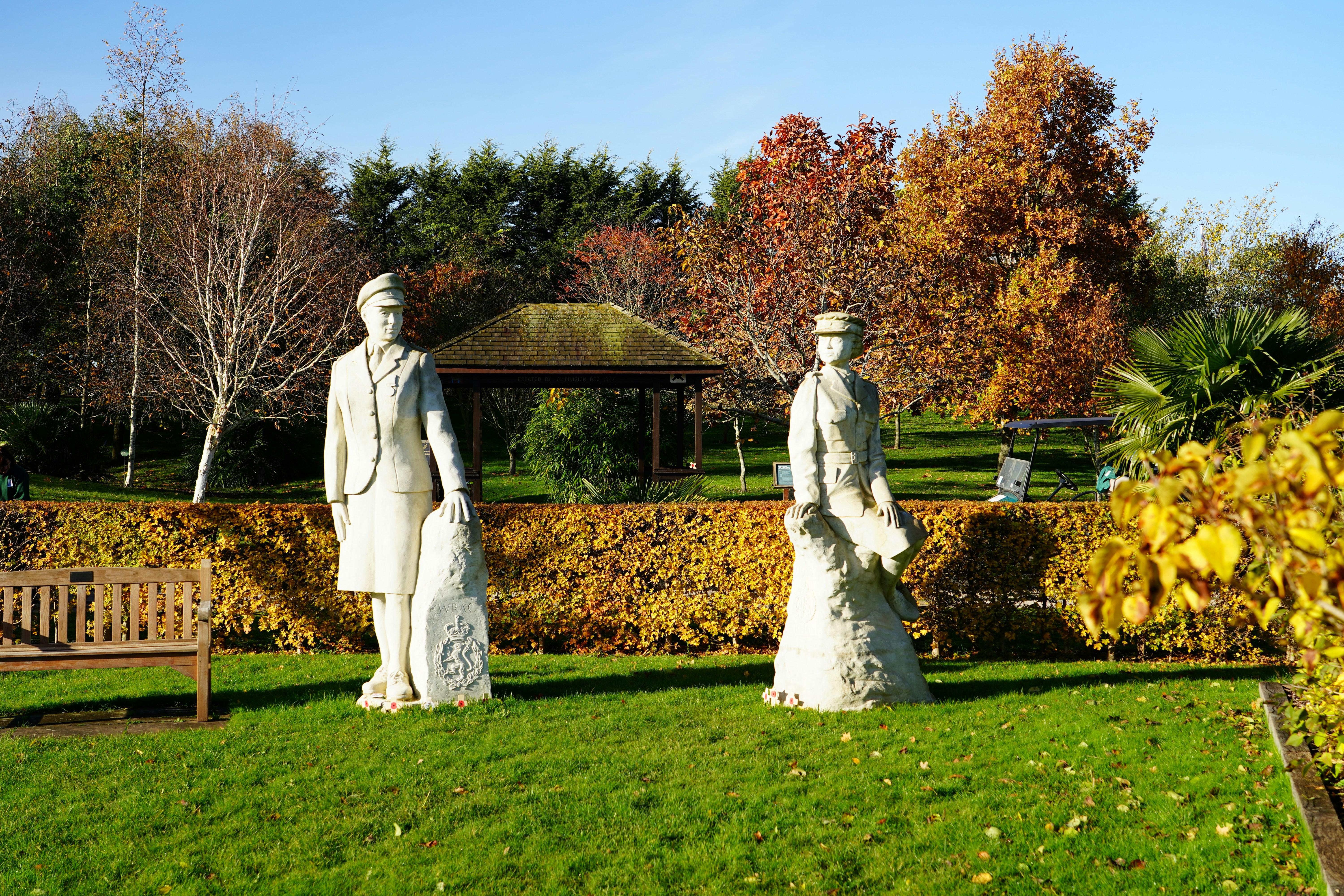 a couple of statues sitting on top of a lush green field