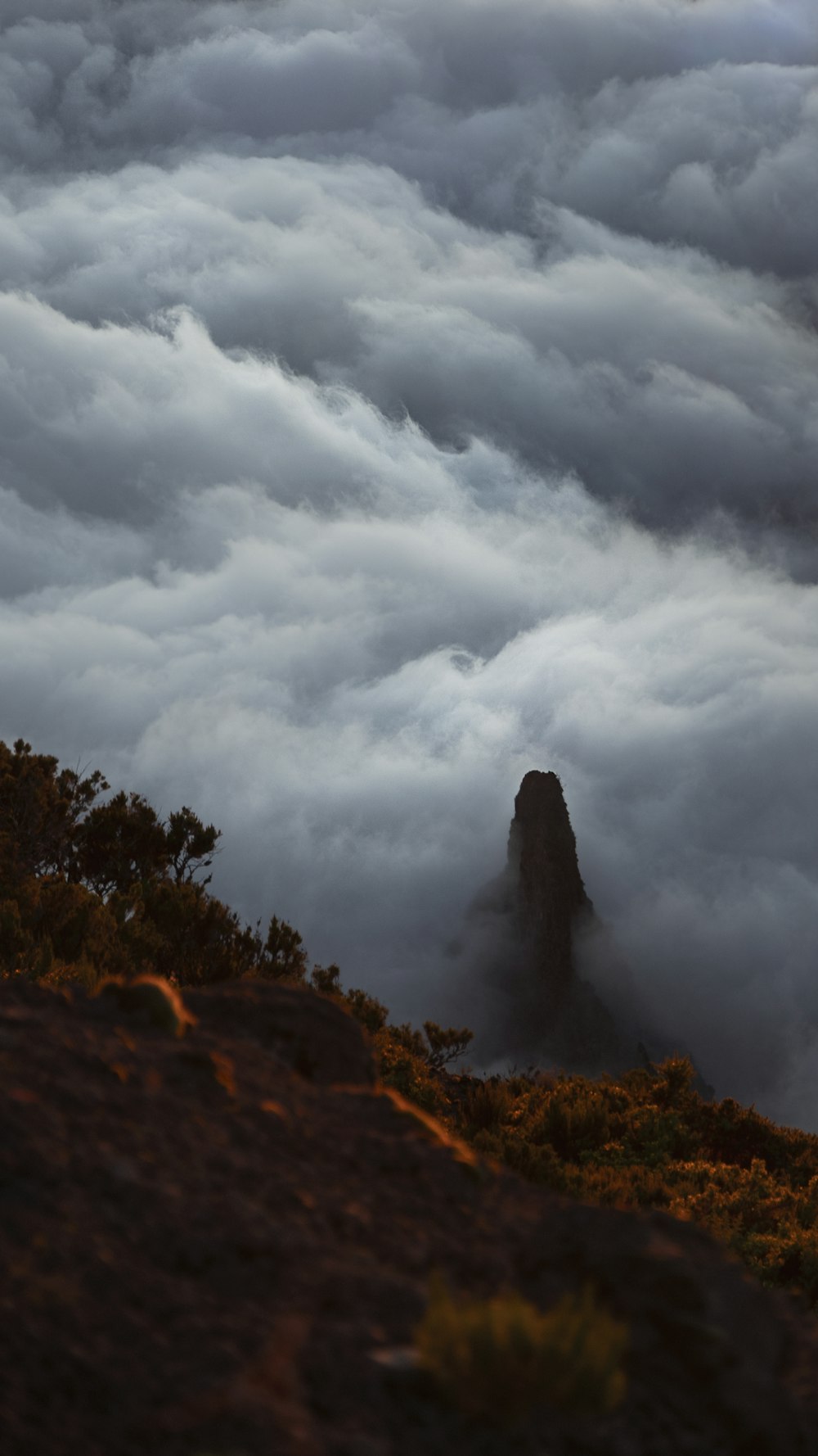 a view of a mountain covered in clouds