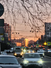 Reflective traffic sign installed on a busy urban street at sunset.