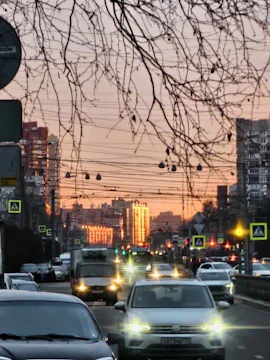 Reflective traffic sign installed on a busy urban street at sunset.