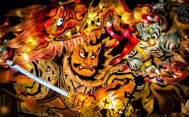 A vibrant and intricate depiction of figures in traditional Japanese warrior attire, surrounded by dynamic swirling colors and patterns. The central figure wields a glowing blue sword, facing intense expressions from mythical creatures.