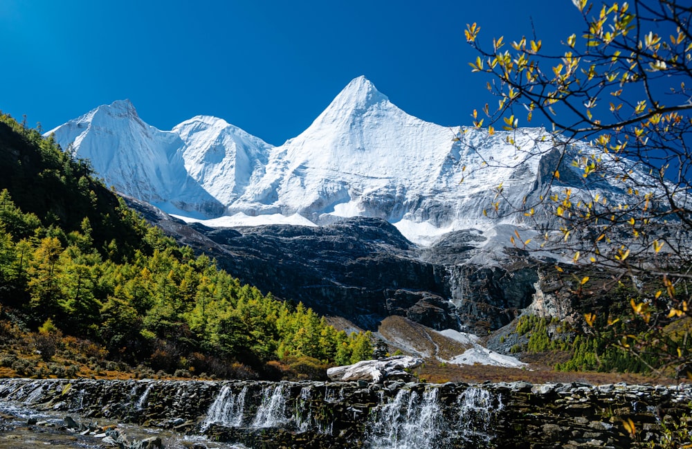 a mountain range with a waterfall in the foreground