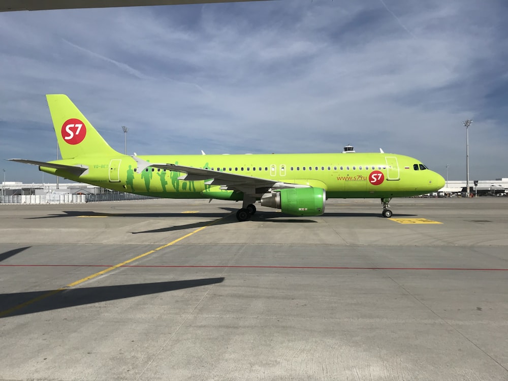 a bright green airplane sitting on the tarmac