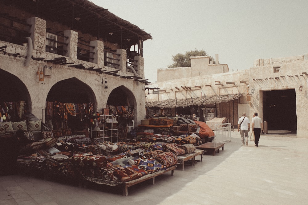 a couple of people walking past a market