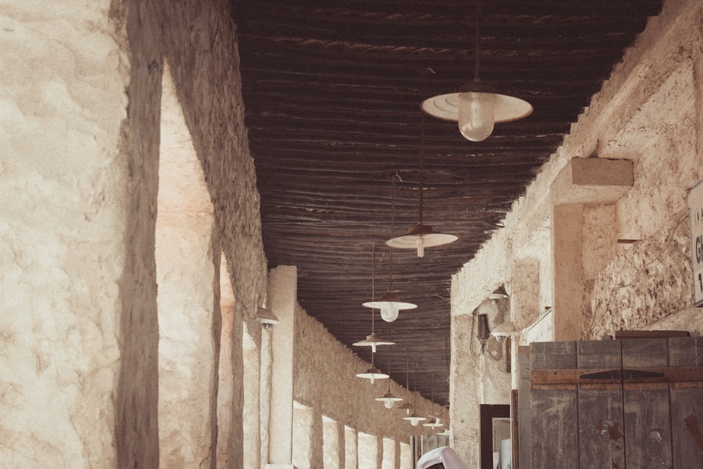 a woman walking down a long hallway between two buildings