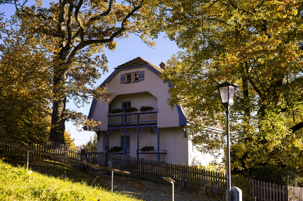 a white house with a blue roof and a fence around it