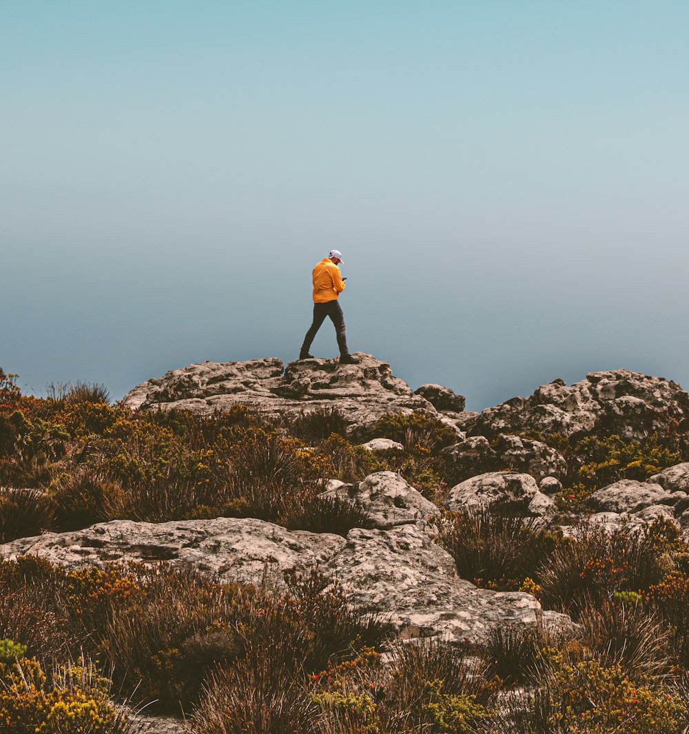 a man standing on top of a rocky hill