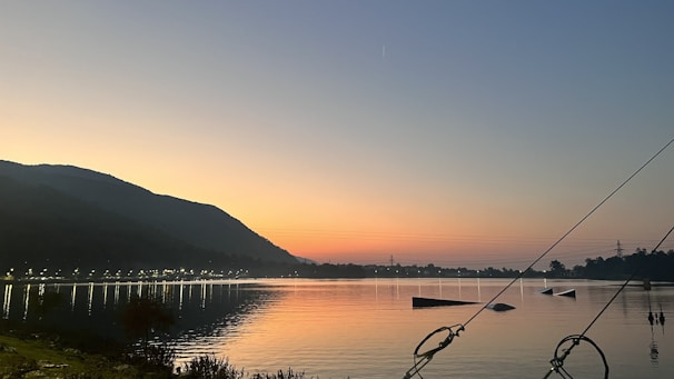 Sunset over the calm waters of Lake Argentino with mountains in the background.