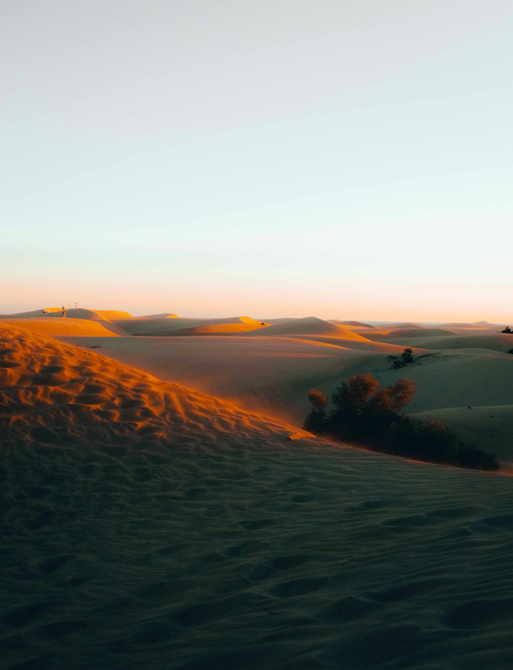 the sun is setting over the sand dunes