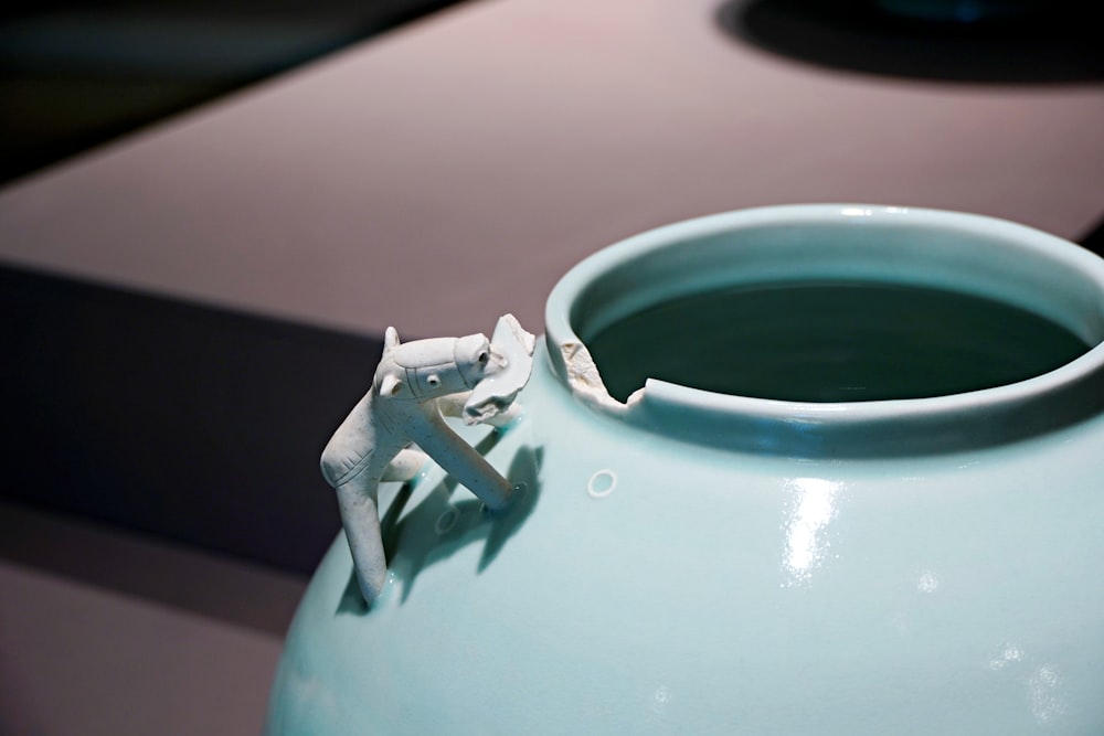 a blue vase sitting on top of a table