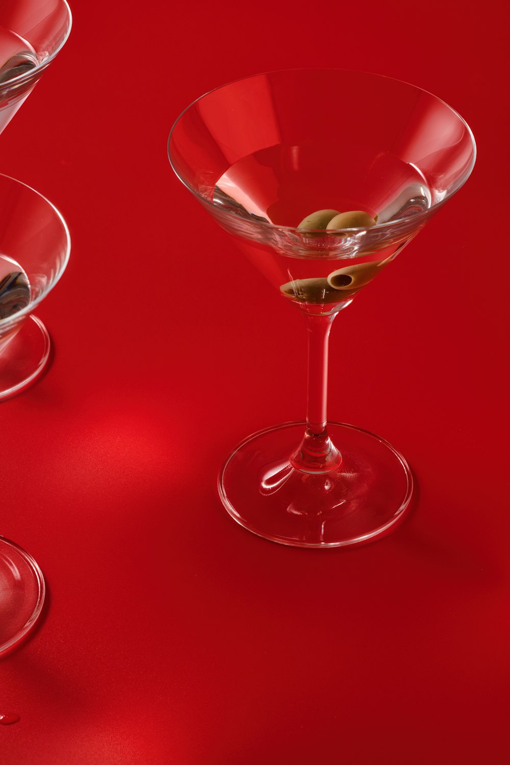 ein roter Tisch mit zwei Weingläsern, die mit Oliven gefüllt sind