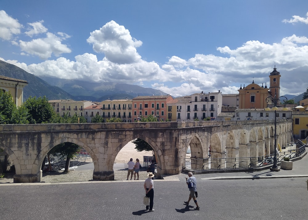 a couple of people walking across a bridge