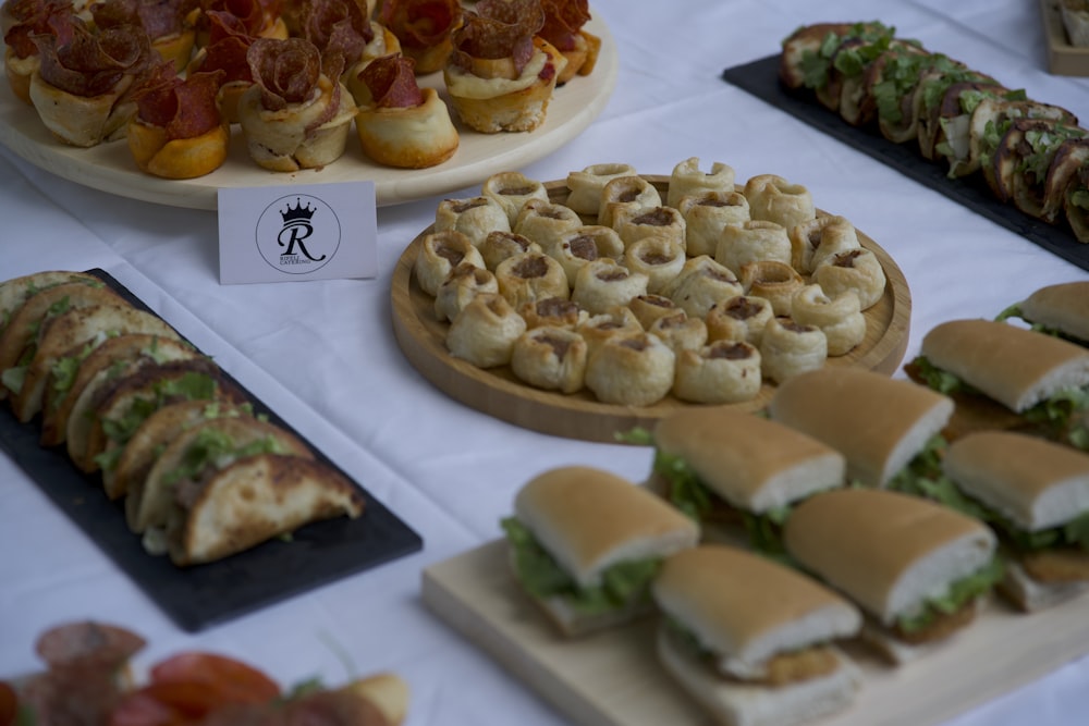 a table topped with lots of different types of sandwiches