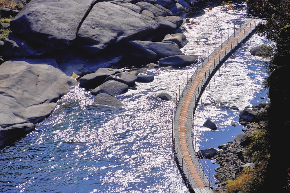 a bridge over a body of water next to rocks