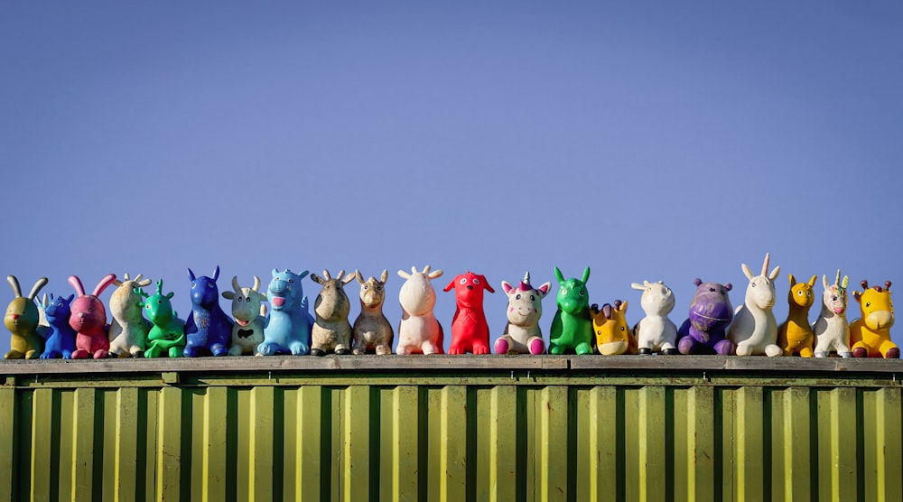 Eine Gruppe von Spielzeugtieren sitzt auf einem grünen Behälter