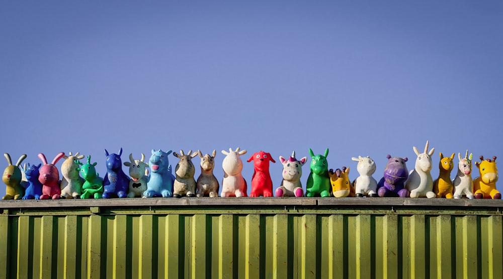 a group of toy animals sitting on top of a green container