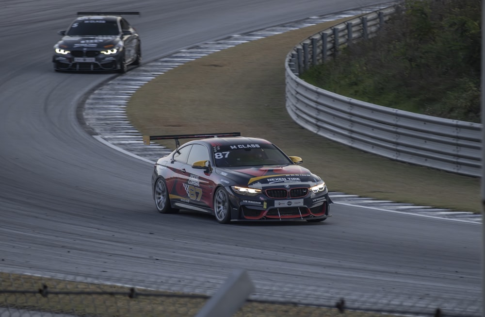 two cars driving on a race track next to each other