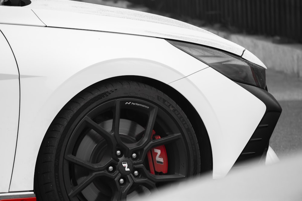 a close up of a white car with black rims