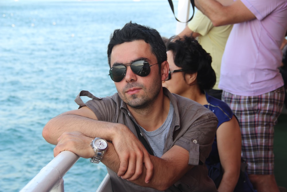 a man wearing sunglasses sitting on a boat