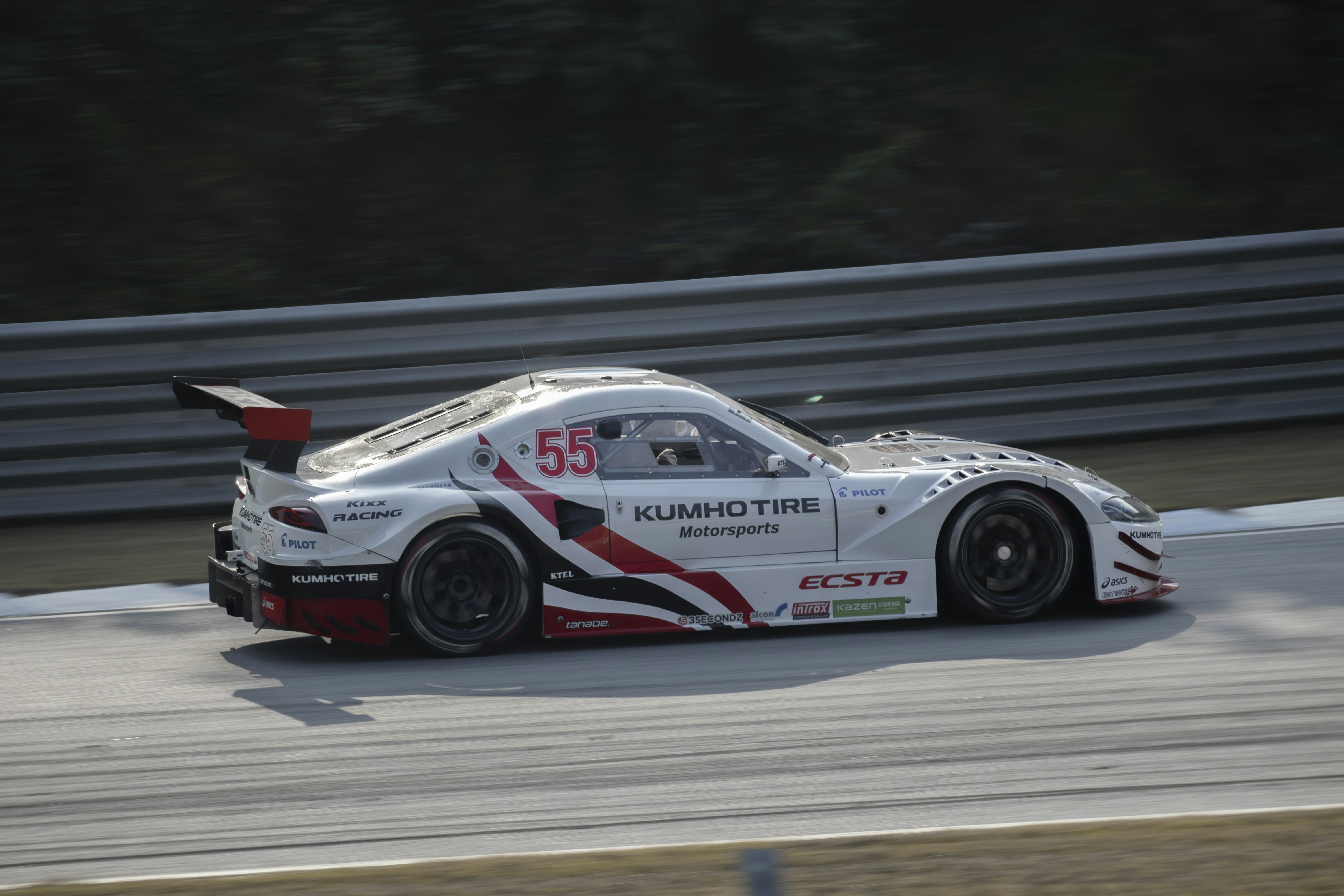 une voiture de course blanche roulant sur une piste de course