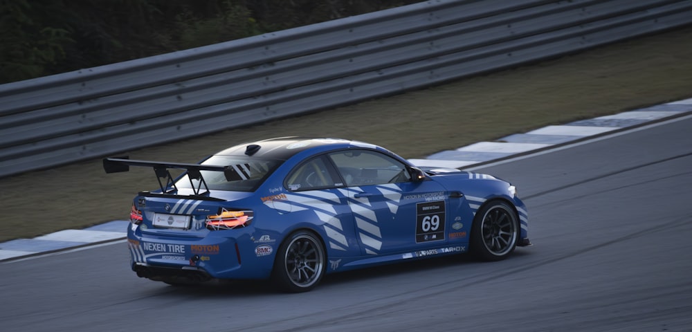 a blue car driving down a race track