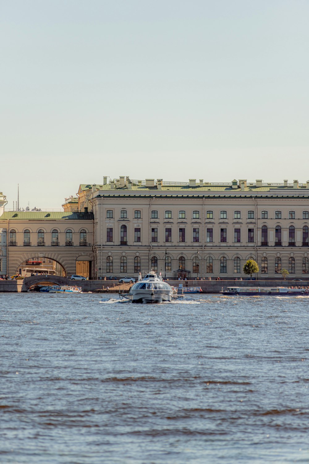 a boat is in the water in front of a large building