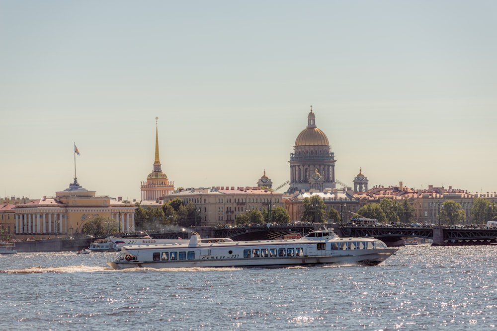 a boat traveling down a river next to a city