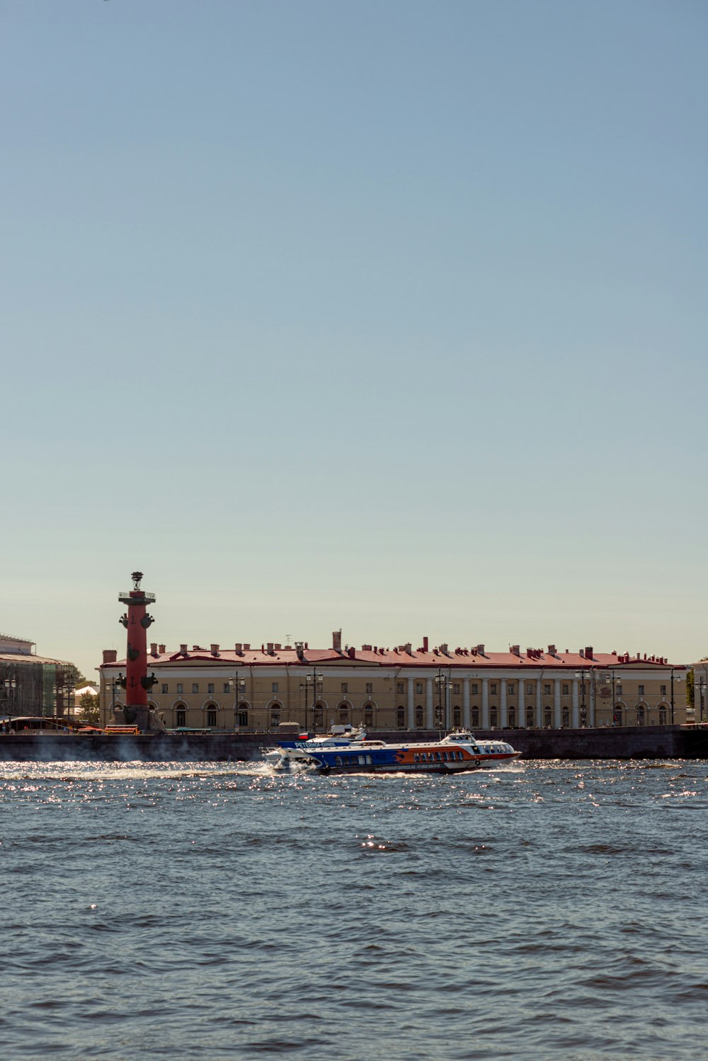 um corpo de água com barcos em frente a um edifício