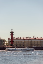 A sleek boat cruising along the Motlawa River at sunset with Gdansk’s historic skyline in the background.