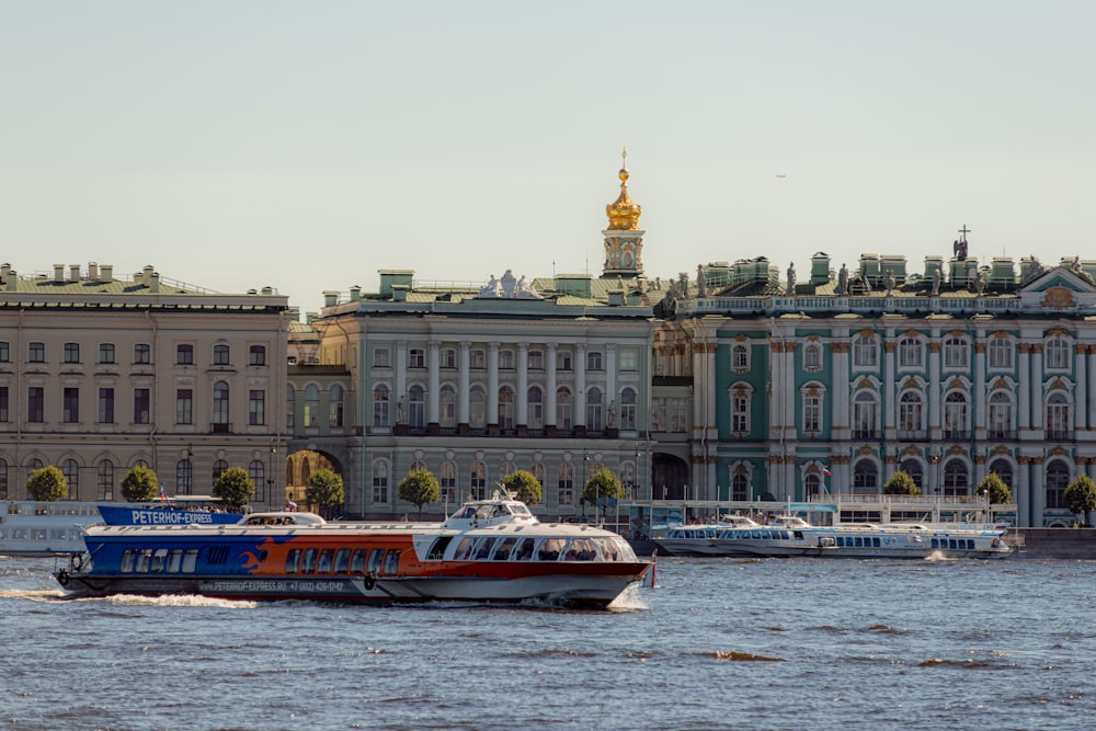 a boat traveling down a river in front of a large building